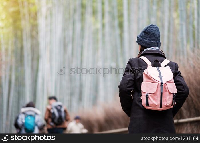 Young Woman Traveling at Arashiyama Bamboo Grove, Happy Asian traveler looking Sagano Bamboo Forest. landmark and popular for tourists attractions in Kyoto, Japan. Asia travel concept