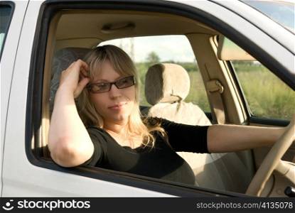 young woman travelling by car on nature background