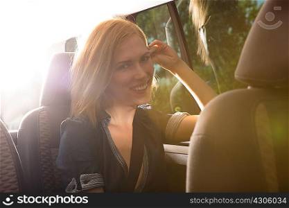 Young woman travelling in back seat of car