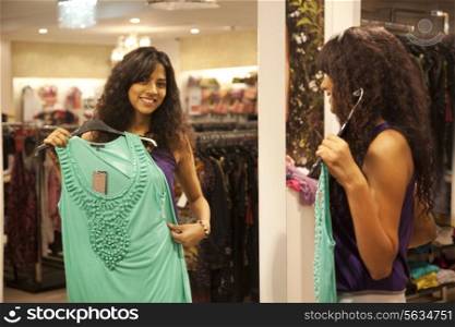 Young woman trying on dress at store