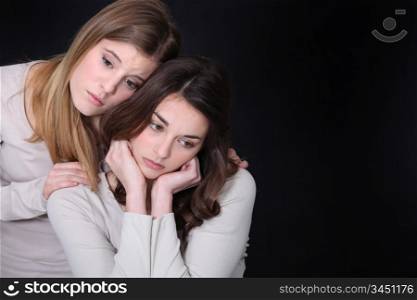 Young woman trying to comfort her friend