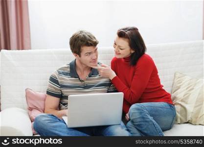 Young woman trying to distract boyfriend from laptop