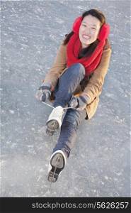 Young Woman Tying Ice Skates Outside