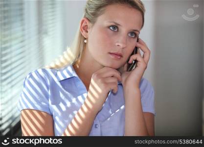 Young woman using a cellphone in an office