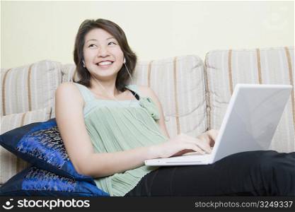 Young woman using a laptop and smiling