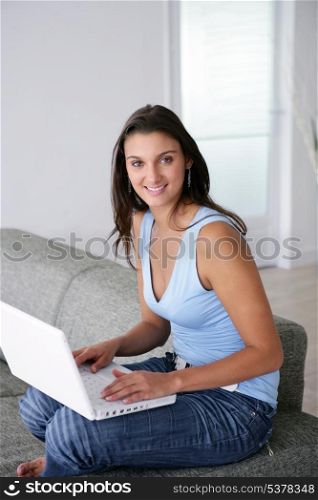 Young woman using a laptop computer on a sofa