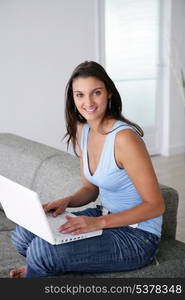 Young woman using a laptop computer on a sofa