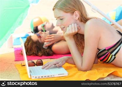 Young woman using a laptop computer on the beach
