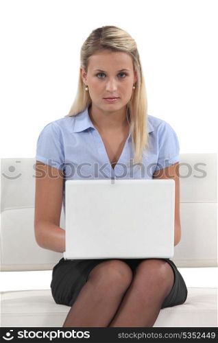 Young woman using a laptop on a sofa