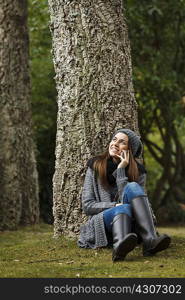Young woman using cellular phone in forest