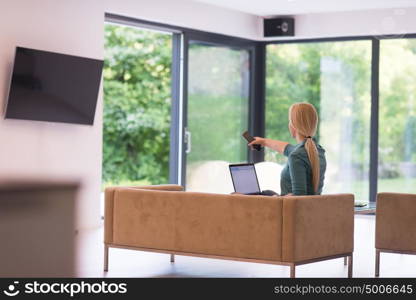 Young woman using her laptop computer in her luxury modern home, smiling