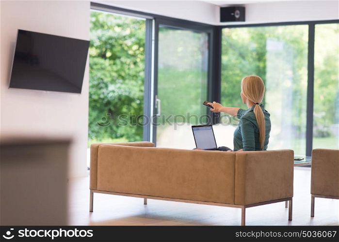 Young woman using her laptop computer in her luxury modern home, smiling