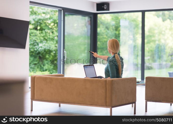 Young woman using her laptop computer in her luxury modern home, smiling