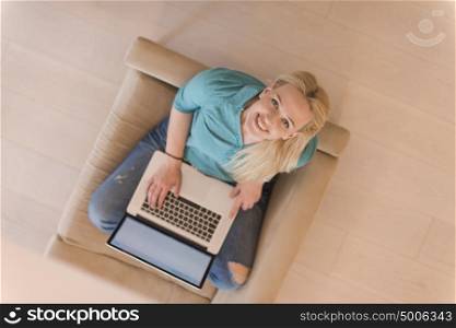 Young woman using her laptop computer in her luxury modern home top view