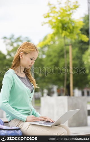 Young woman using laptop at college campus