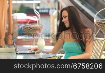 Young woman Using Laptop at Outdoor Cafe