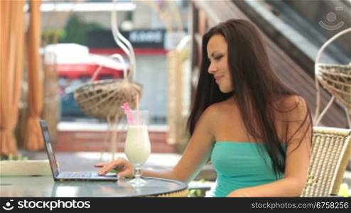 Young woman Using Laptop at Outdoor Cafe