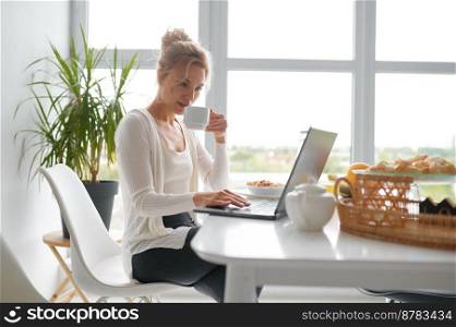 Young woman using laptop computer on home kitchen. Millennial female studying or working online while having video call conference or chatting on internet social media. Young woman using laptop on home kitchen