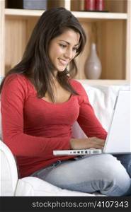 Young Woman Using Laptop Sitting At Home