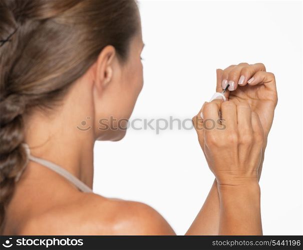Young woman using nail polish . rear view