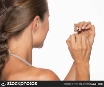 Young woman using nail polish . rear view