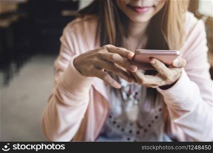 Young woman using smart phone and drinking coffee in cafe. Young woman using smart phone