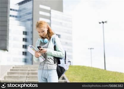 Young woman using smart phone at college campus