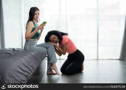 Young woman using smartphone in living room at home with a friend who is looking forward to asking for reconciliation, The concept of love LGBT