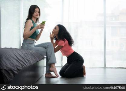 Young woman using smartphone in living room at home with a friend who is looking forward to asking for reconciliation, The concept of love LGBT
