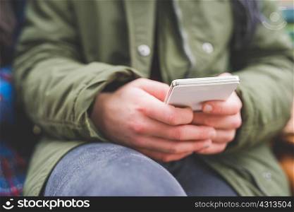 Young woman using smartphone, outdoors, close-up