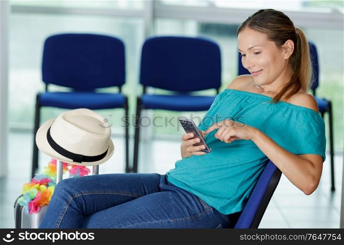 young woman using smartphone while waiting at airport