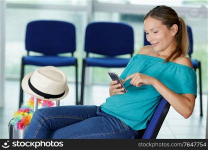 young woman using smartphone while waiting at airport