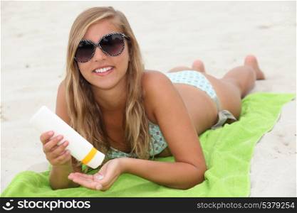 Young woman using sun cream