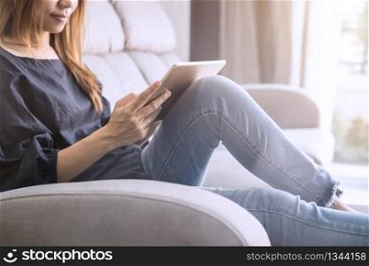 Young woman using tablet on sofa at home