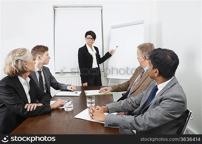 Young woman using whiteboard in business meeting