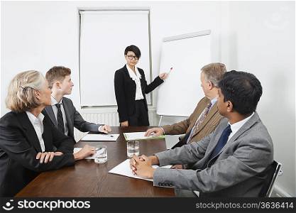 Young woman using whiteboard in business meeting