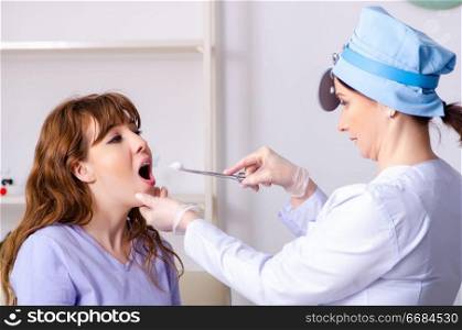 Young woman visiting female doctor otolaryngologist . Young woman visiting female doctor otolaryngologist