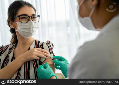 Young woman visits skillful doctor at hospital for vaccination . Covid 19 and coronavirus vaccination center service concept .. Young woman visits skillful doctor at hospital for vaccination