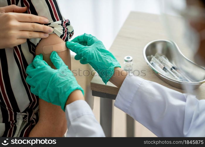 Young woman visits skillful doctor at hospital for vaccination . Covid 19 and coronavirus vaccination center service concept .. Young woman visits skillful doctor at hospital for vaccination