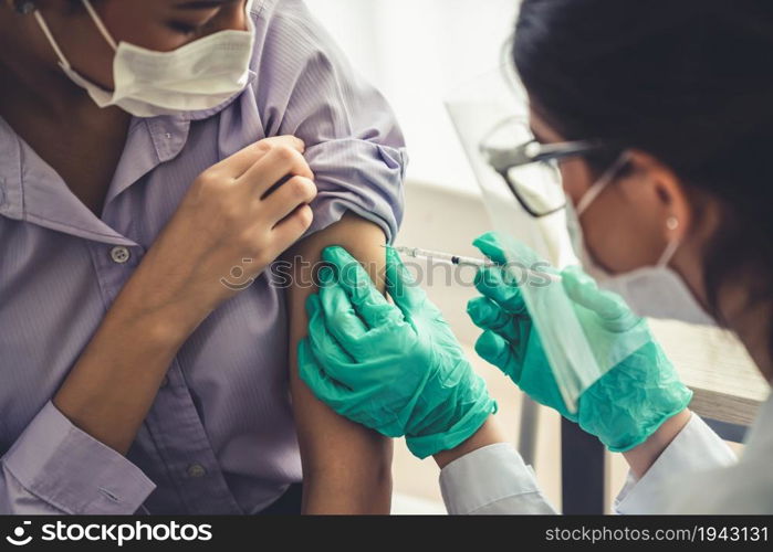 Young woman visits skillful doctor at hospital for vaccination . Covid 19 and coronavirus vaccination center service concept .. Young woman visits skillful doctor at hospital for vaccination