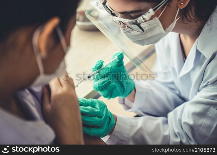 Young woman visits skillful doctor at hospital for vaccination . Covid 19 and coronavirus vaccination center service concept .. Young woman visits skillful doctor at hospital for vaccination