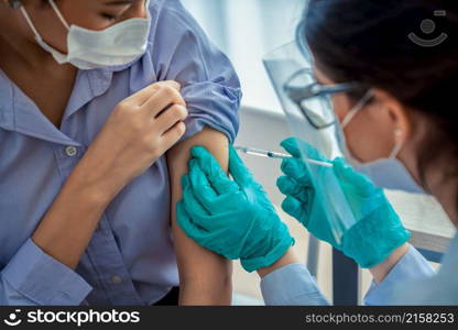 Young woman visits skillful doctor at hospital for vaccination . Covid 19 and coronavirus vaccination center service concept .. Young woman visits skillful doctor at hospital for vaccination