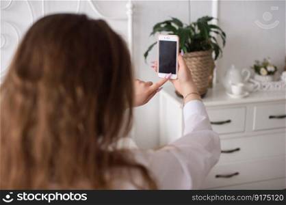 Young Woman vlogger presses record on smart phone screen. A young emotional woman presses the phone button. Without a face