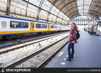 Young woman waiting for the train at central station in Amsterdam the Netherlands