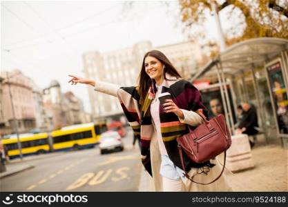 Young woman waiting for transport in the city on streets