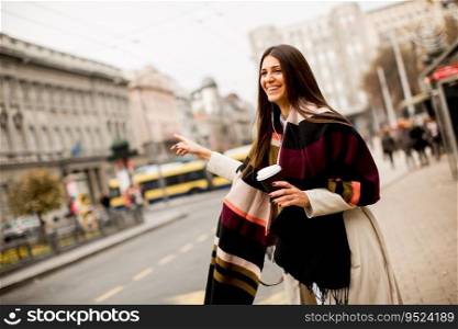 Young woman waiting for transport in the city on streets