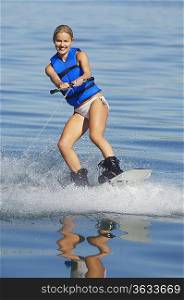 Young woman wakeboarding on lake