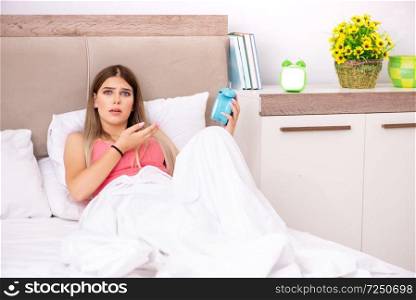 Young woman waking up in the morning in bed