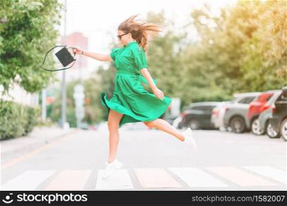 Young woman walking around the big city. Portrait of beautiful girl in green dress. Young woman in green dress in the city walks