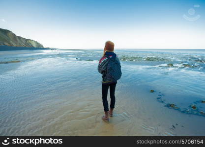 young woman walking by the sea